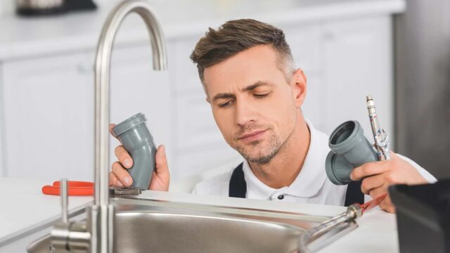 thoughtful-adult-repairman-holding-pipes-and-tools-resize.jpg