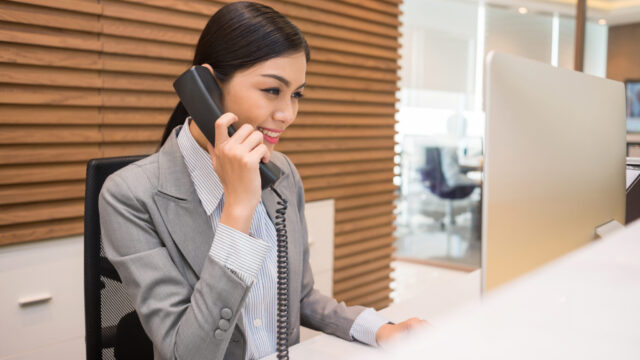 Pretty,Vietnamese,Receptionist,Talking,On,Telephone,At,Her,Workplace